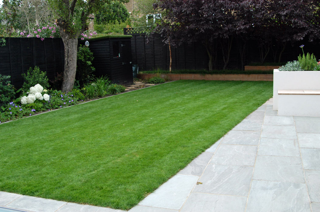 View across lawn, shed is painted same colour as the fence to blend in